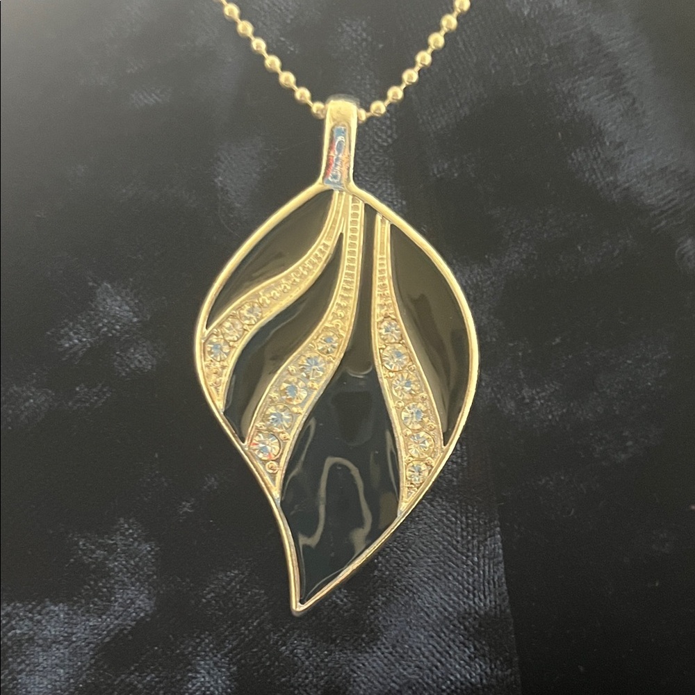 Black, silver tone, with CZ embellishment. Leaf shape pendant.